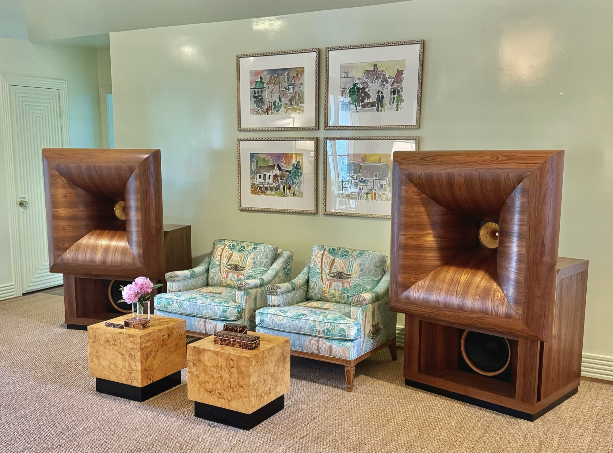 A pair of Semrad Audio horn speakers installed in a private listening room, flanking two upholstered armchairs and burl wood side tables.